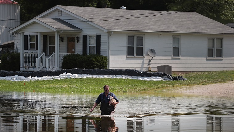 BARNHART, MISSOURI - MAY 31: David Nibarger walks through floodwater from the the Mississippi River as he leaves his home with his dog Tiny under his arm on May 31, 2019 in Barnhart, Missouri. The middle-section of the country has been experiencing major flooding since mid-March especially along the Missouri, Arkansas, and Mississippi Rivers. Towns along the Mississippi River have been experiencing the longest stretch of major flooding from the river in nearly a century.