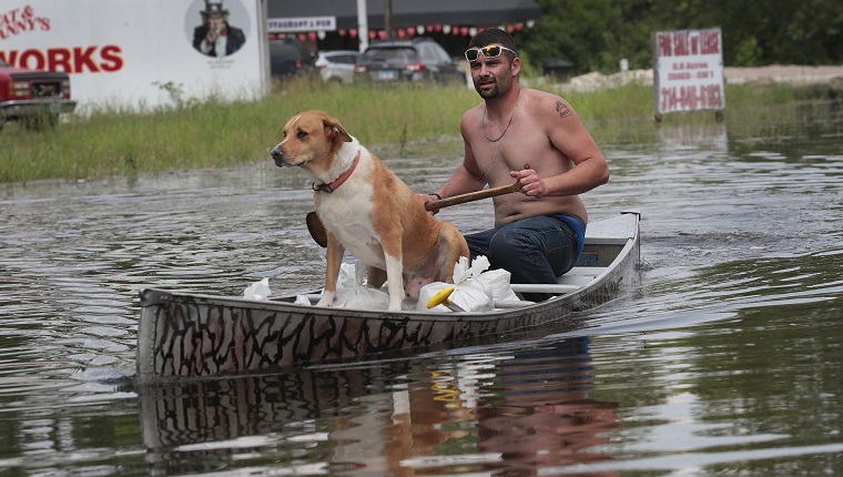 BARNHART, MISSOURI - MAY 31: Ryan Sizemore paddles down Highway 61 with his dog Rico as he hauls sandbags to his home to hold back rising floodwater from the Mississippi River on May 31, 2019 in Barnhart, Missouri. The middle-section of the country has been experiencing major flooding since mid-March especially along the Missouri, Arkansas, and Mississippi Rivers. Towns along the Mississippi River have been experiencing the longest stretch of major flooding from the river in nearly a century.